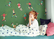 cute yawning kid in pajamas sitting in bed