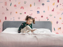 A charming little girl jumps on the bed and laughs
